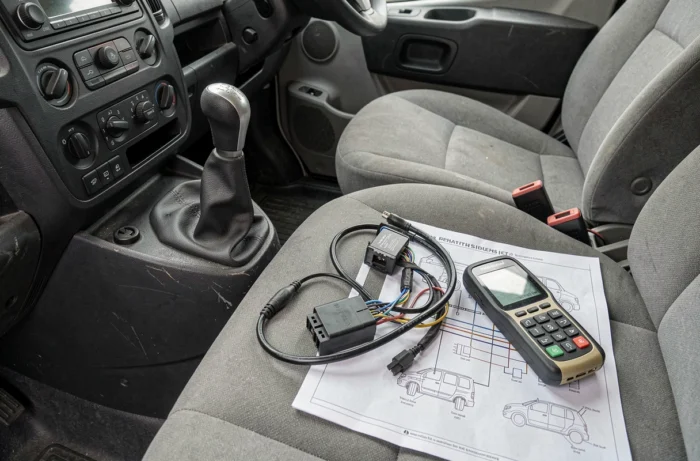 Scanner de diagnostic OBD2 et module antidémarrage Peugeot Boxer posés sur le siège conducteur